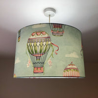 Light blue lampshade with hot air balloon design on a plain background.