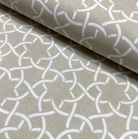Retro mid century upholstery fabric with a white geometric floral pattern on a beige background.