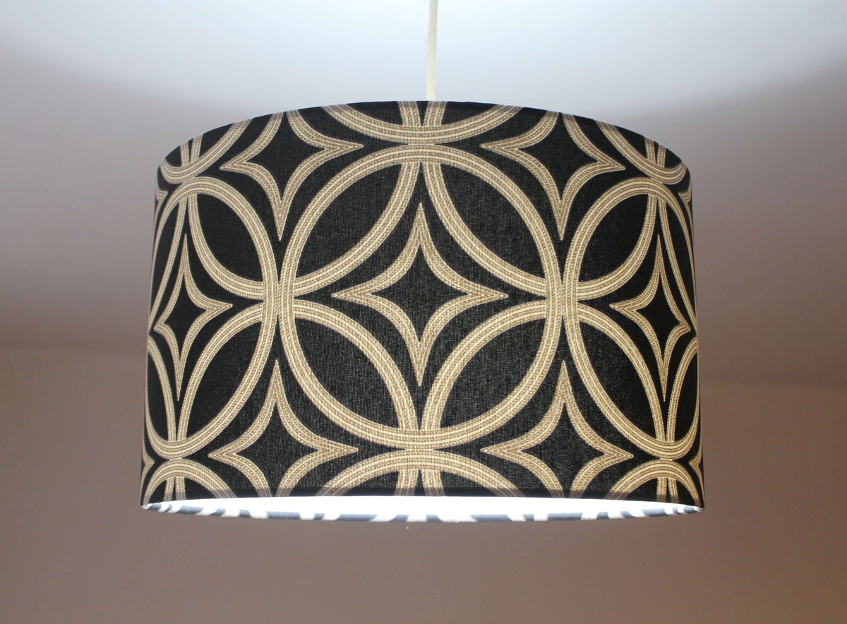A black and beige mid century geometric patterned lampshade on a white background.