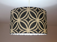 A black and beige mid century geometric patterned lampshade on a white background.