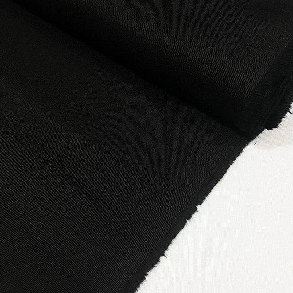 Black cotton duck canvas fabric with a tightly woven texture, suitable for upholstery, curtains, chair covers, bags, and outdoor projects.
