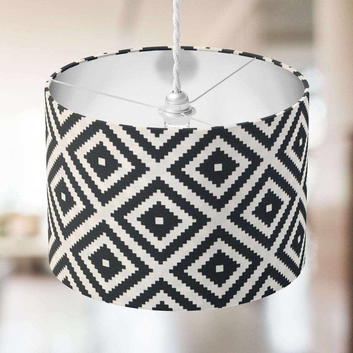 Black and white monochrome diamond patterned lampshade on a blurred background.