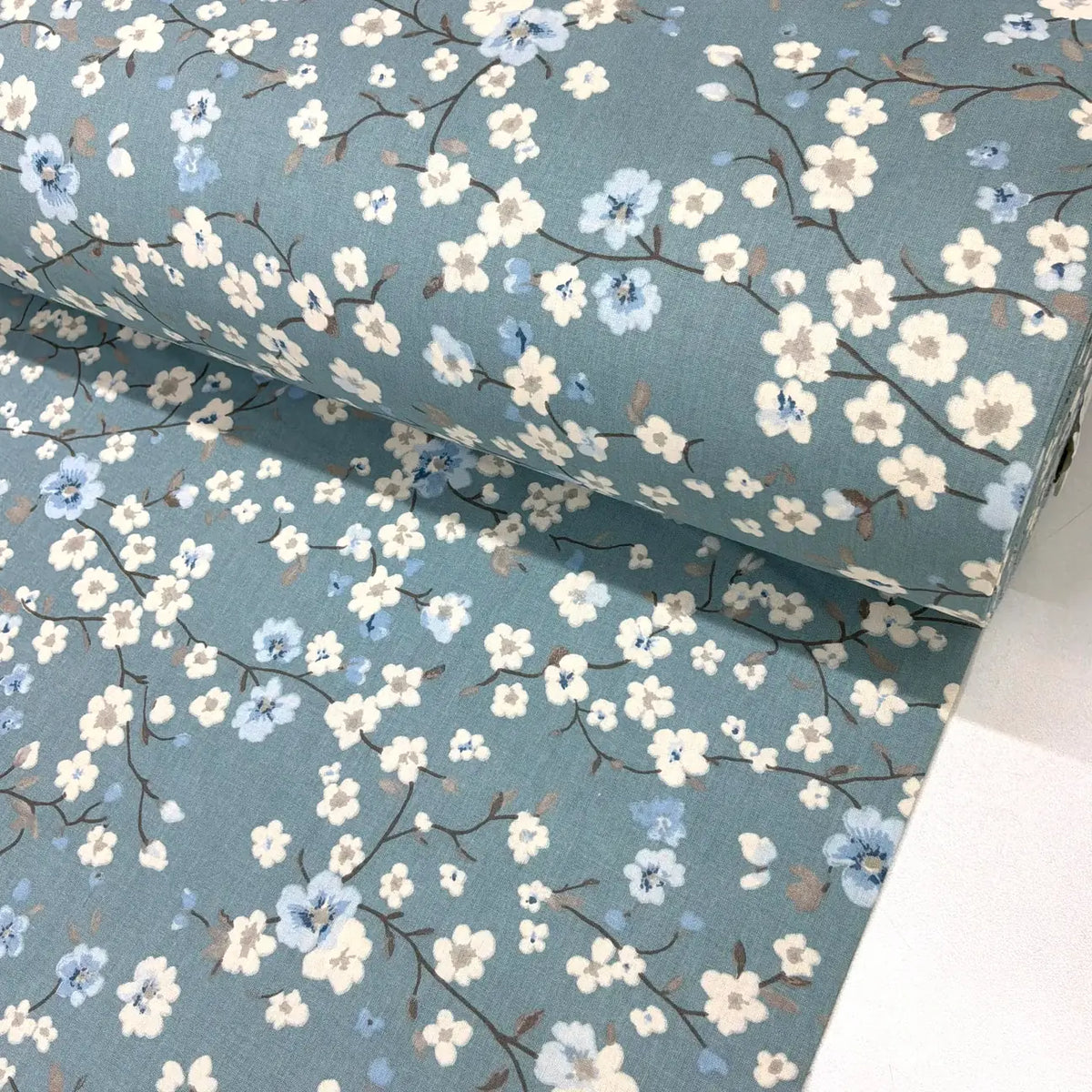 Blue floral cotton fabric with Japanese-inspired white and blue blossom flowers on an indigo blue background.