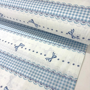 Blue gingham bow cotton poplin fabric featuring striped bands, ribbon bows and lace-effect borders on a white background.