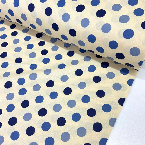 Blue polka dot cotton fabric with navy and cornflower blue spots on a cream background, ideal for dressmaking, quilting, patchwork and craft projects.