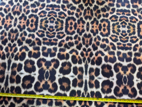 Brown leopard print upholstery fabric with a measuring tape at the bottom.