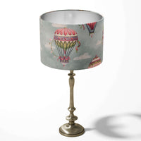 Decorative table lampshade featuring hot air balloons and white clouds on a light blue background.