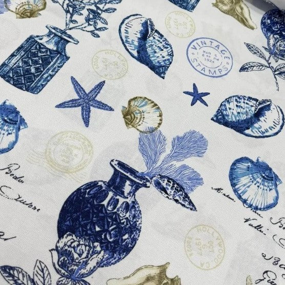 Coastal blue ocean upholstery fabric patterned with seashells, starfish, stamps.