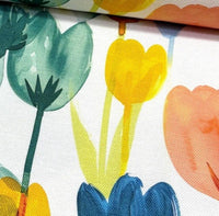 Close-up of colourful floral fabric with tulips on a white background.