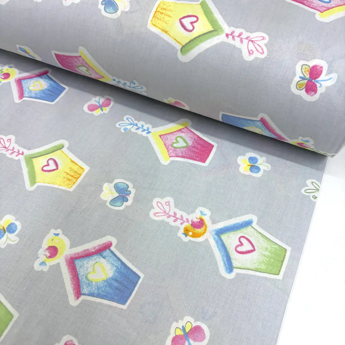 Cotton poplin fabric with colorful birdhouse and butterfly patterns on a grey background.