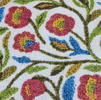 Embroidery patterned floral upholstery fabric in burgundy red, mustard yellow, blue, green and white.