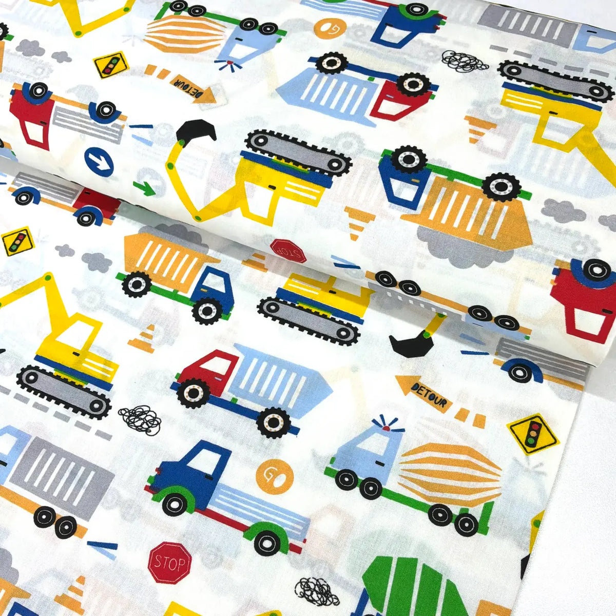 Construction vehicles cotton fabric featuring colourful diggers, dump trucks, excavators, lorries and roadwork signs on a white background.