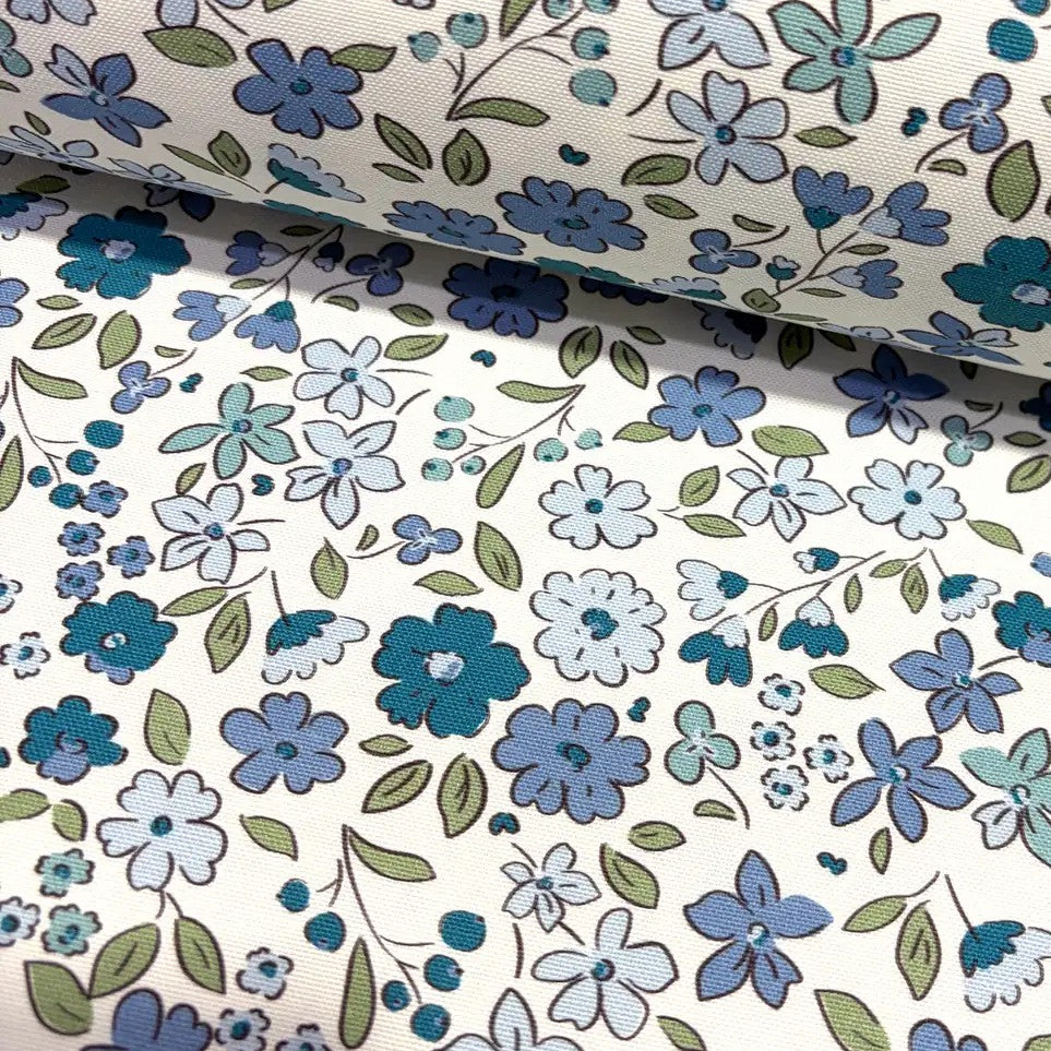 Tiny wildflower fabric patterned with indigo blue flowers on a white background.