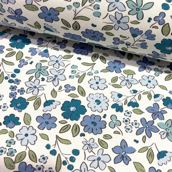 Tiny wildflower fabric patterned with indigo blue flowers on a white background.