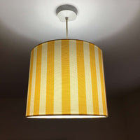 A yellow and white farmhouse striped  lampshade designed for table lamps, floor lamps, or ceiling pendants. 