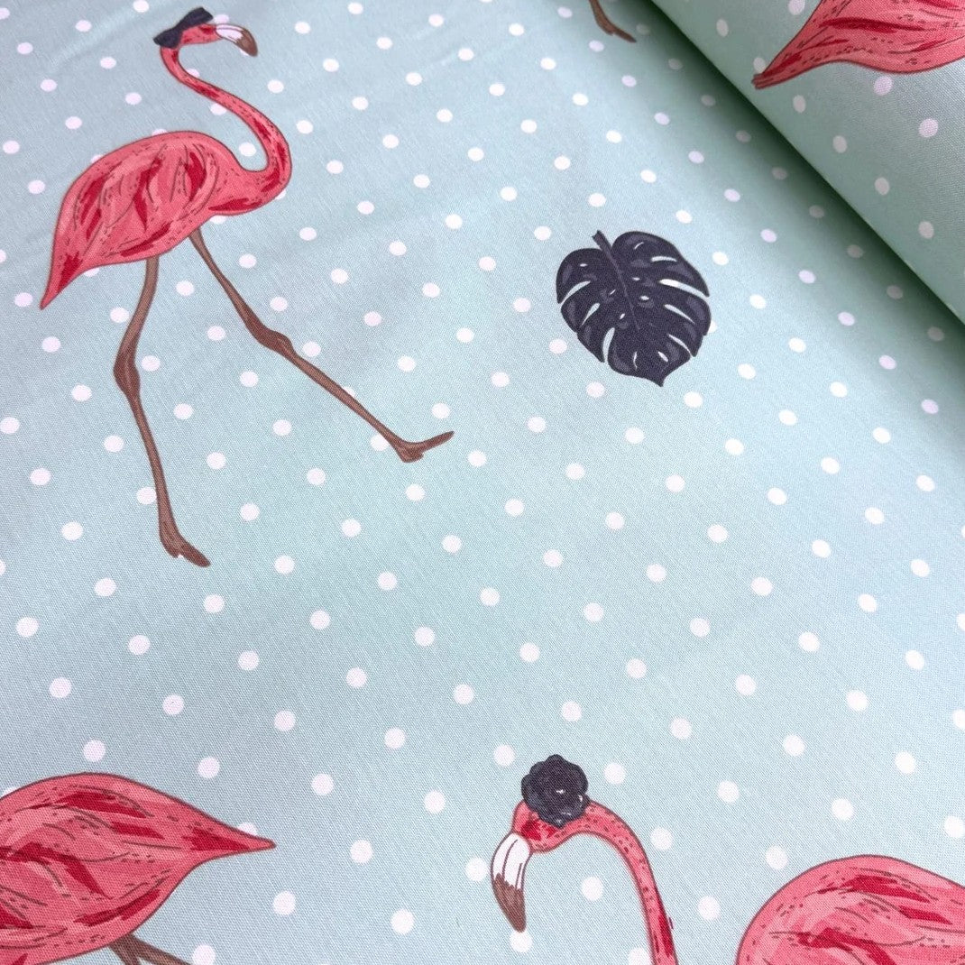Pink flamingo and dark grey monstrea leaves print fabric on a mint green dotted upholstery fabric.
