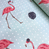 Pink flamingo and dark grey monstrea leaves print fabric on a mint green dotted upholstery fabric.