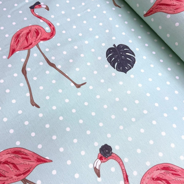 Pink flamingo and dark grey monstrea leaves print fabric on a mint green dotted upholstery fabric.