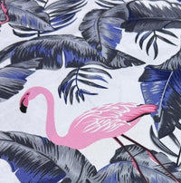Fabric printed with pink flamingo and tropical leaves pattern on a white background.