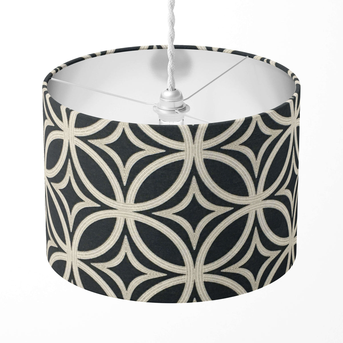 A black and beige geometric patterned lampshade on a white background.