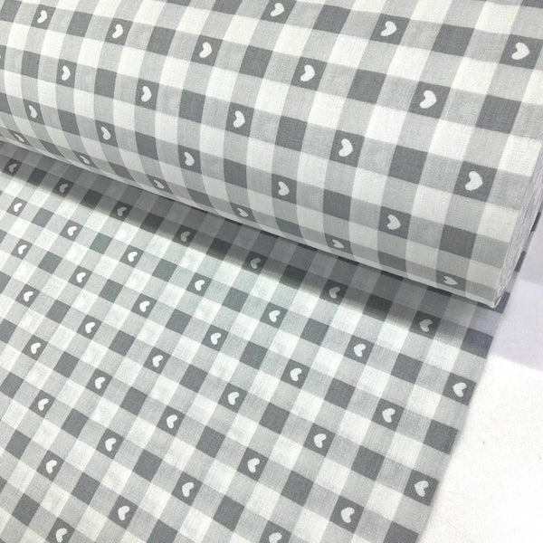 Grey cotton gingham fabric with white heart print, featuring a classic check pattern, ideal for dressmaking, quilting, patchwork and craft projects.