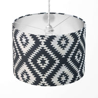 Ikat lampshade with black and white geometric pattern on a white background.