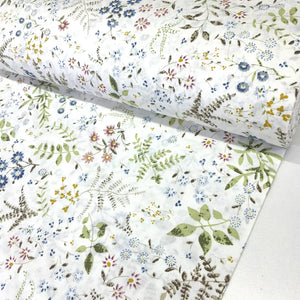 Meadow flower cotton poplin fabric with a botanical floral print featuring blue, pink and mustard flowers on a white background.