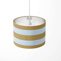 Mustard and white large horizontal stripe patterned ceiling lampshade on a wite background.