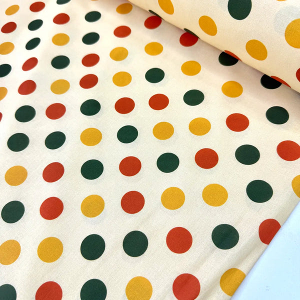 Multicolour polka dot cotton fabric featuring red, yellow and green spots on a cream backgroundç
