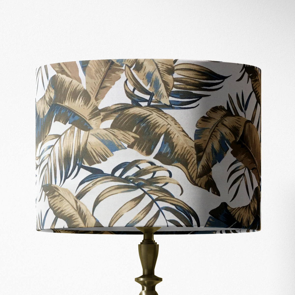 Table and floor lampshade with tropical leaf pattern on a white background.