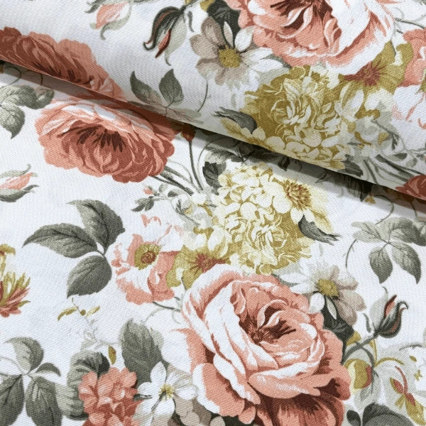 Large print pink rose and yellow flowers upholstery fabric on a white background.