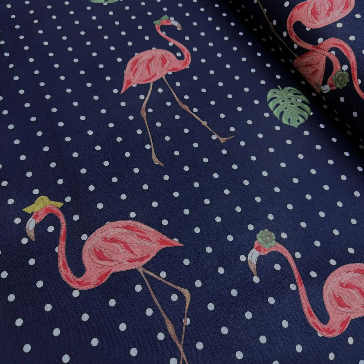 Upholstery & curtain fabric with pink flamingo and polka dot pattern on a navy blue background.