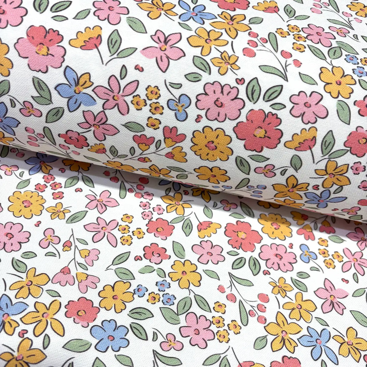 Floral fabric with pink, mustard yellow, and blue flowers on a white background.
