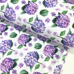 Purple hydrangea cotton poplin fabric featuring lilac and lavender floral blooms with green leaves on a white background.