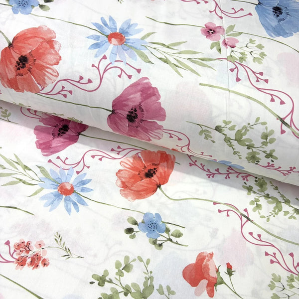 A white cotton poplin fabric with a watercolour floral print featuring red poppies, pink flowers, blue daisies, and green leaves.