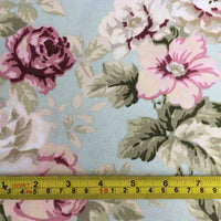 Pink floral fabric pattern with a ruler at the bottom for scale on a light blue background.