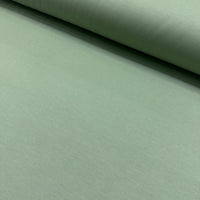 Sage green cotton canvas fabric with a plain woven texture, ideal for upholstery, curtains, cushions, bags, crafts, and soft furnishing projects.
