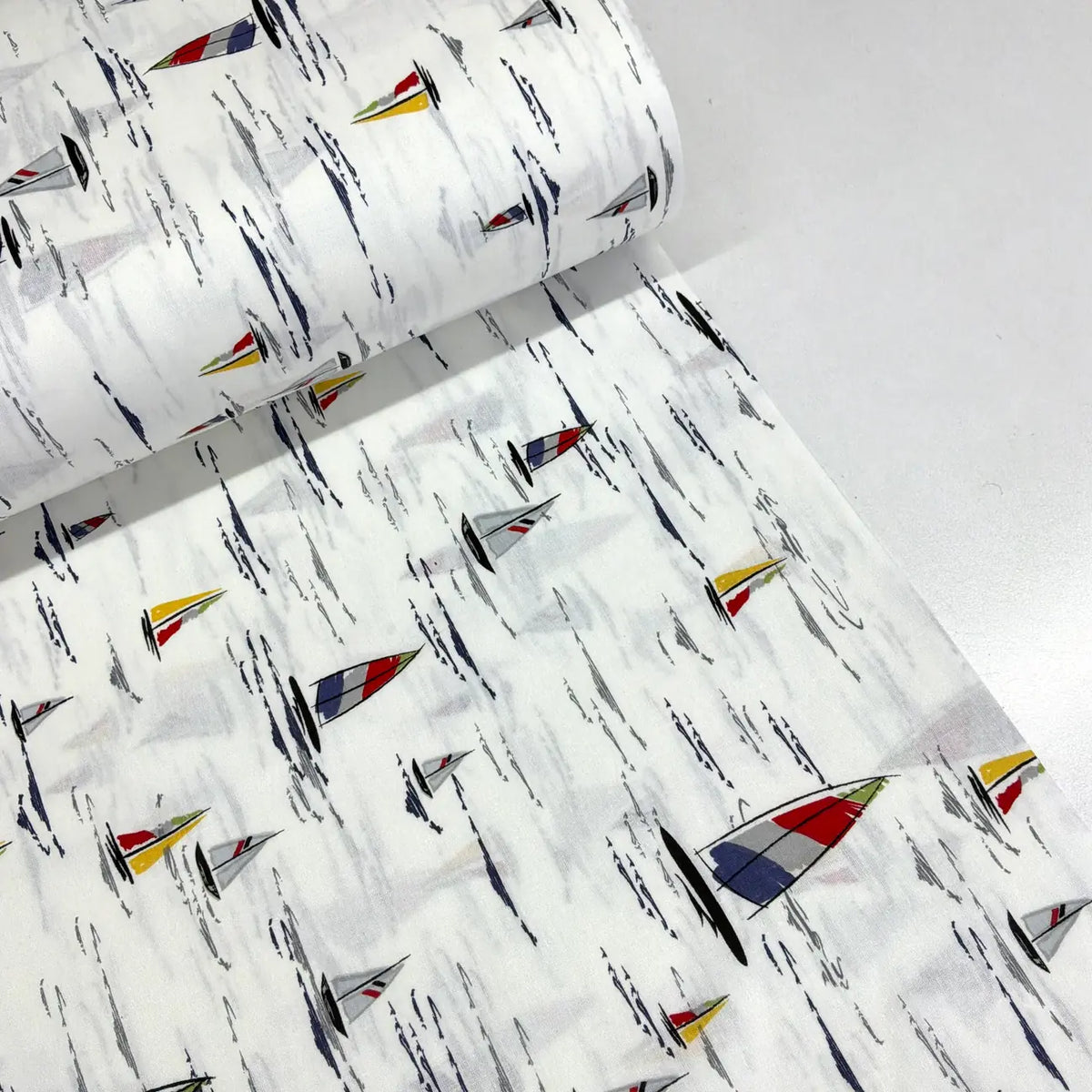 100% cotton sailing boats fabric featuring colourful nautical sailboats on a white water-effect background, ideal for quilting, dressmaking, patchwork and craft projects.