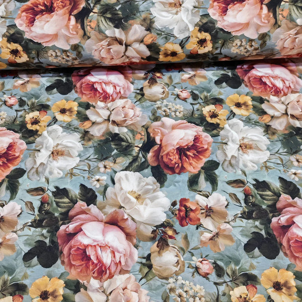 Floral patterned fabric with pink, white, and yellow flowers on a blue background.