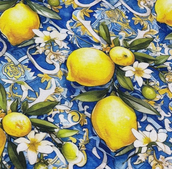 Patterned upholstery & curtain fabric with yellow lemons, flowers, and leaves on a blue background.