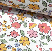 Small floral upholsterty & curtain fabric patterned with colorful flowers and leaves on a white background.