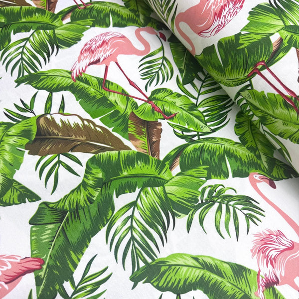 Tropical upholstery fabric with pink flamingo and green leaves pattern on a white background.