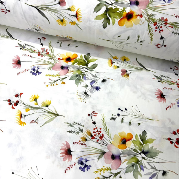 White cotton poplin fabric featuring colourful watercolour wildflower bouquets and botanical foliage, ideal for dressmaking, quilting, patchwork and craft projects.
