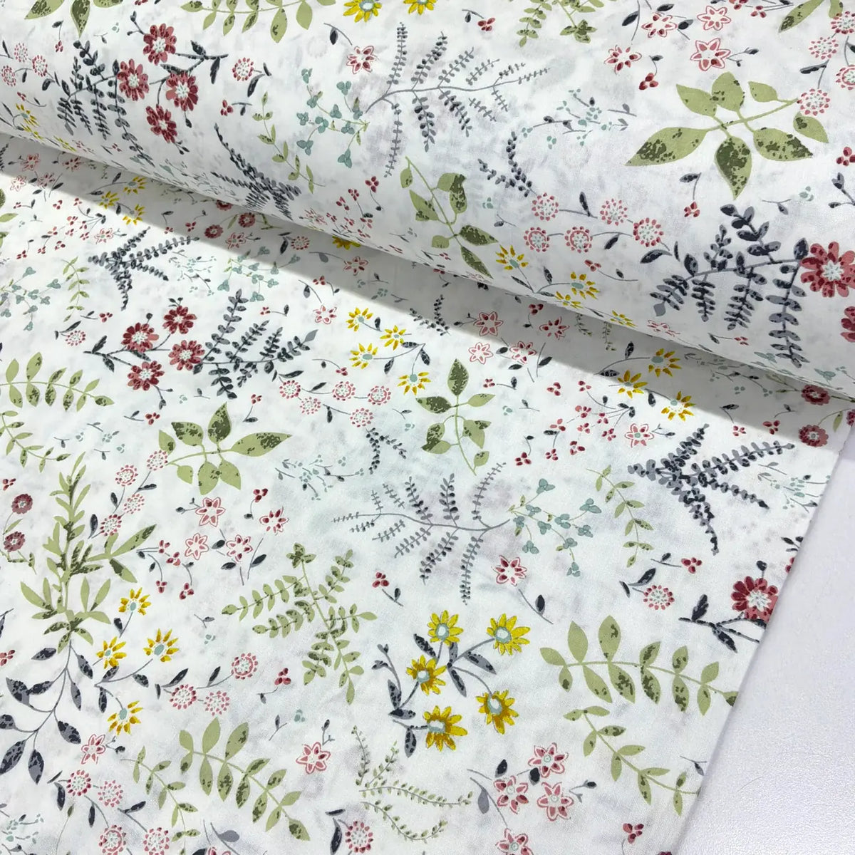 Wildflower botanical cotton fabric featuring green foliage and burgundy, yellow and grey flowers on a white background.