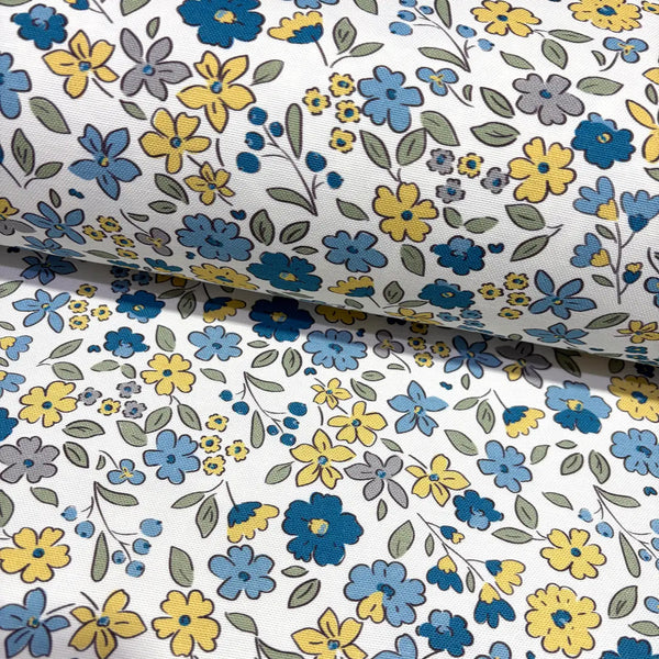 Floral upholstery & curtain fabric patterned with blue, yellow, and gray flowers on a white background.