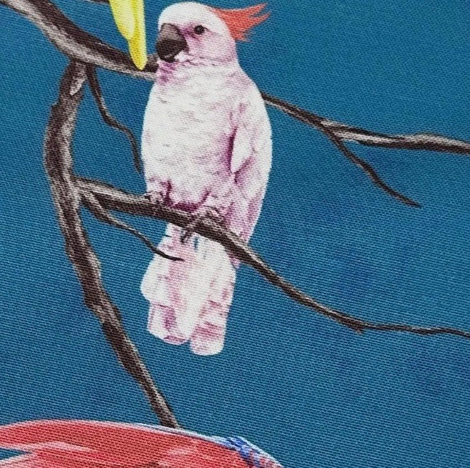 Fabric designed with light pink parrot on a teal blue background.