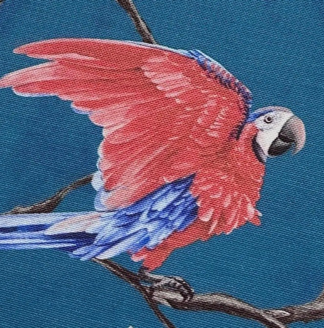 Upholstery curtain fabric orinted in red blue exotic parrot on a blue background.