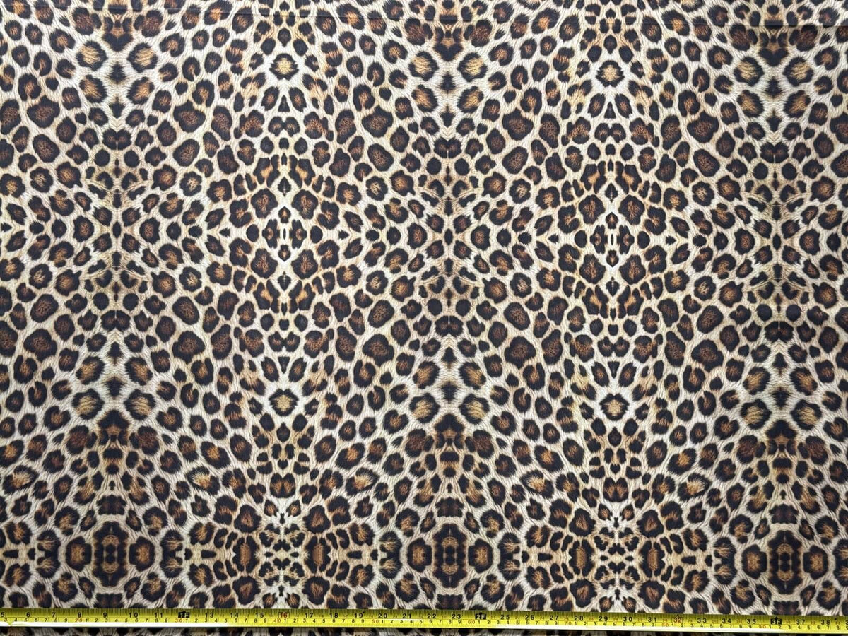 Brown leopard print upholstery fabric with a measuring tape at the bottom.
