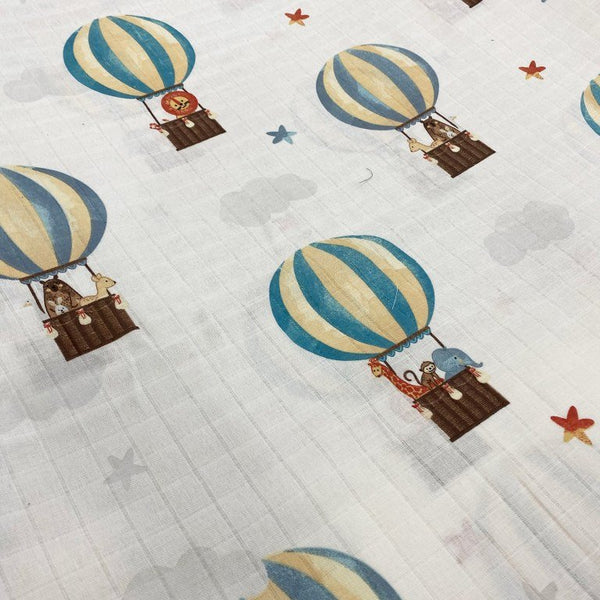 A close-up shot of a lightweight muslin  featuring a whimsical nursery pattern.