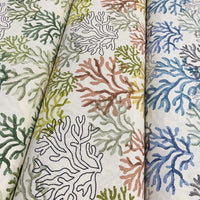 3 rolls of ocean upholstery fabrics patterned with respectively green, yellow and blue coral reefs.